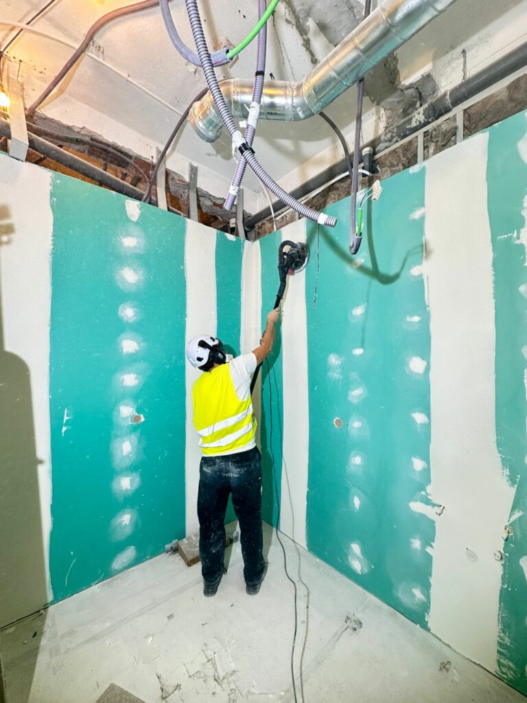 rodrigo com máquina girafa de lixar paredes